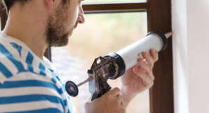 Diy Man Applying Glue On Window Shutterstock 186918203